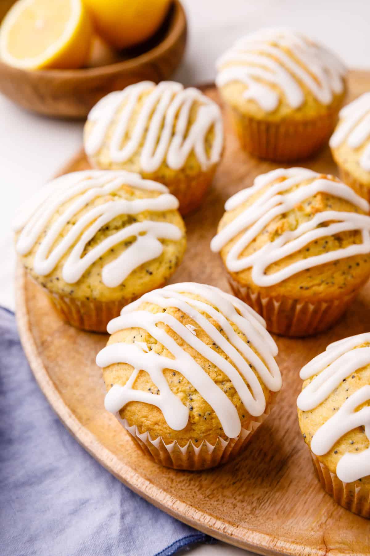 baked lemon poppy seed muffins with glaze served on a wooden plate