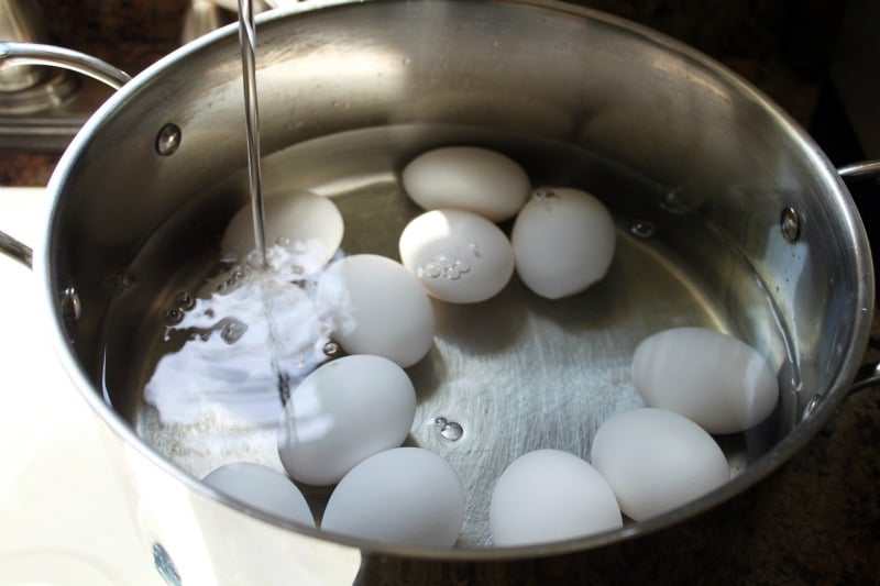 boiling eggs in a pot on the stove 