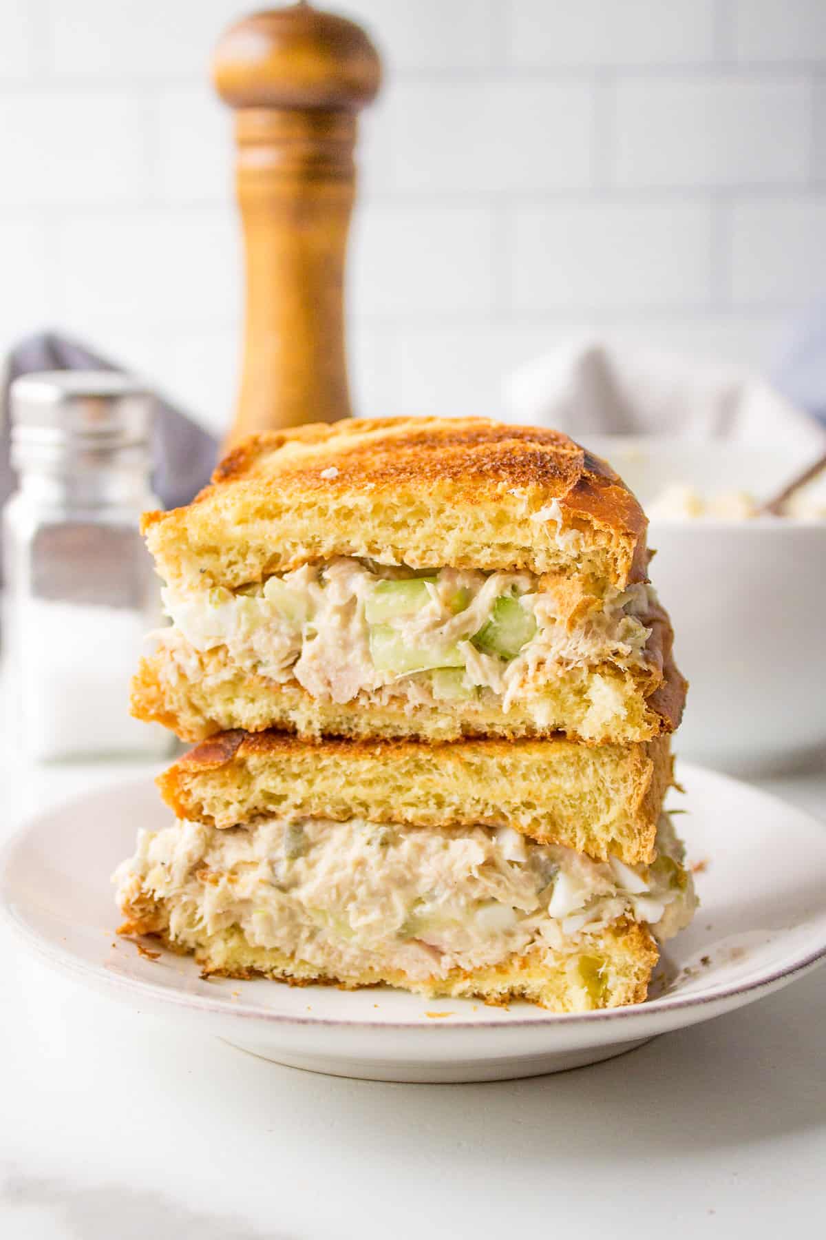 stack of tuna salad sandwiches on a white round plate