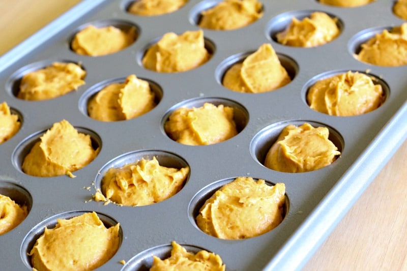 adding muffin mixture to the muffin tin
