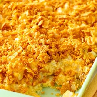Cheesy Potatoes in a baking dish with a scoop missing.