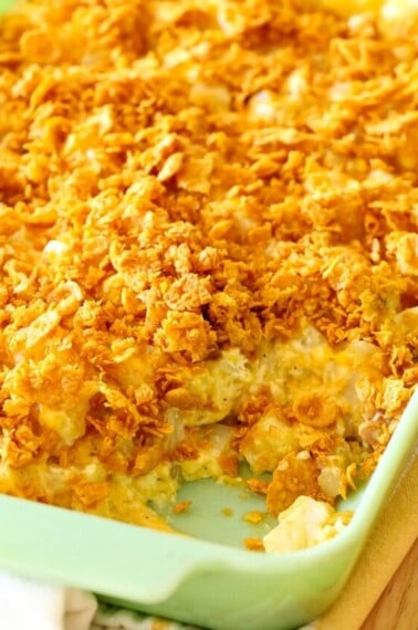 Cheesy Potatoes in a baking dish with a scoop missing.