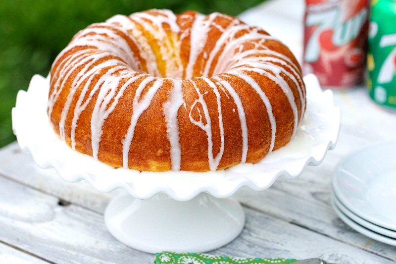 7UP Bundt Cake whole on a table with white plates and soda cans