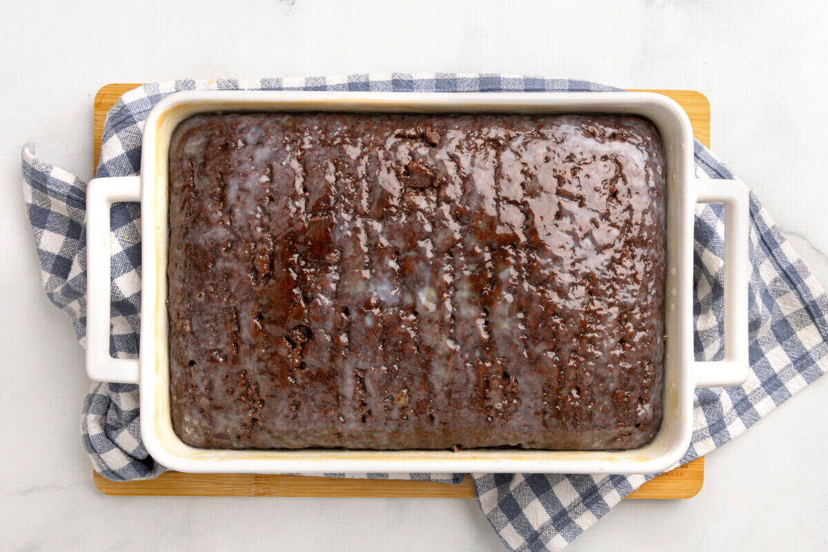 Chocolate cake in a 9x13 baking dish with caramel sauce poured over the entire cake. 