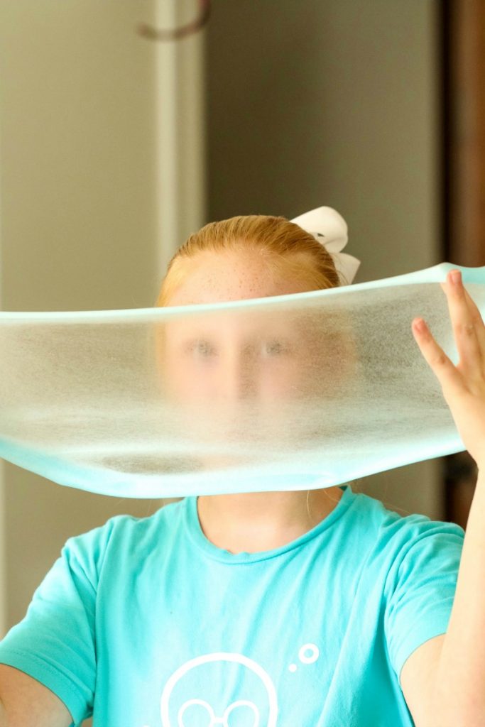 girl stretching incredible clear slime recipe 