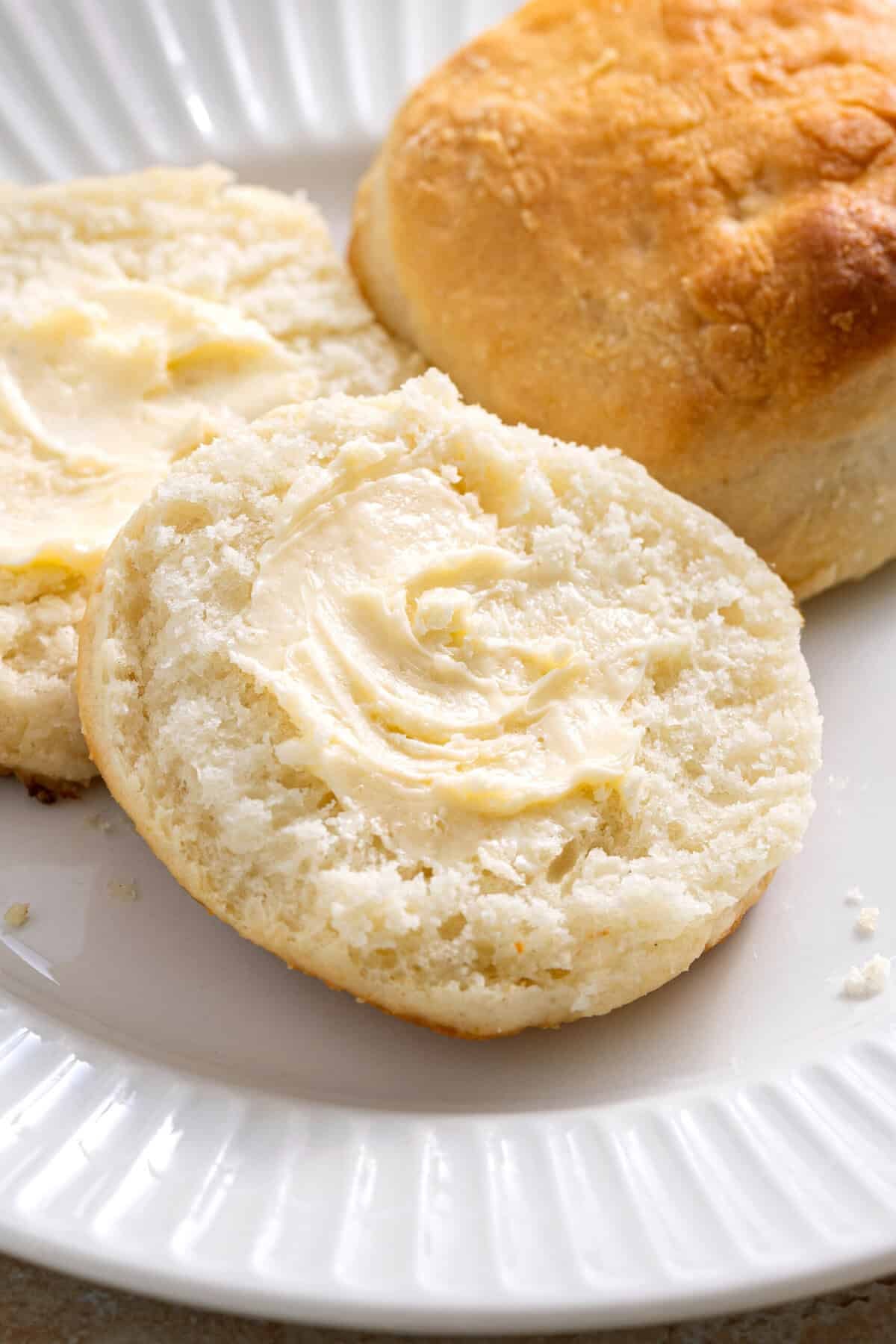 Sprite biscuit cut in half with butter spread onto both sides.