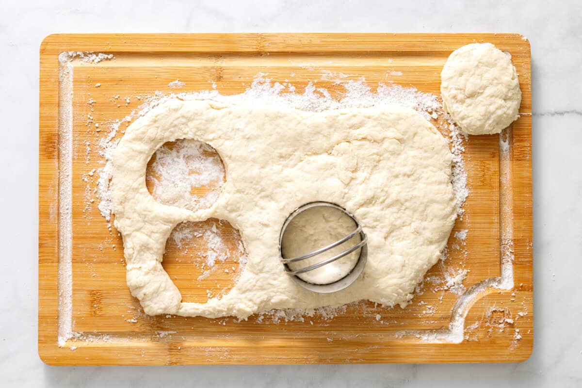Sprite biscuit dough on cutting board being cut into rounds.