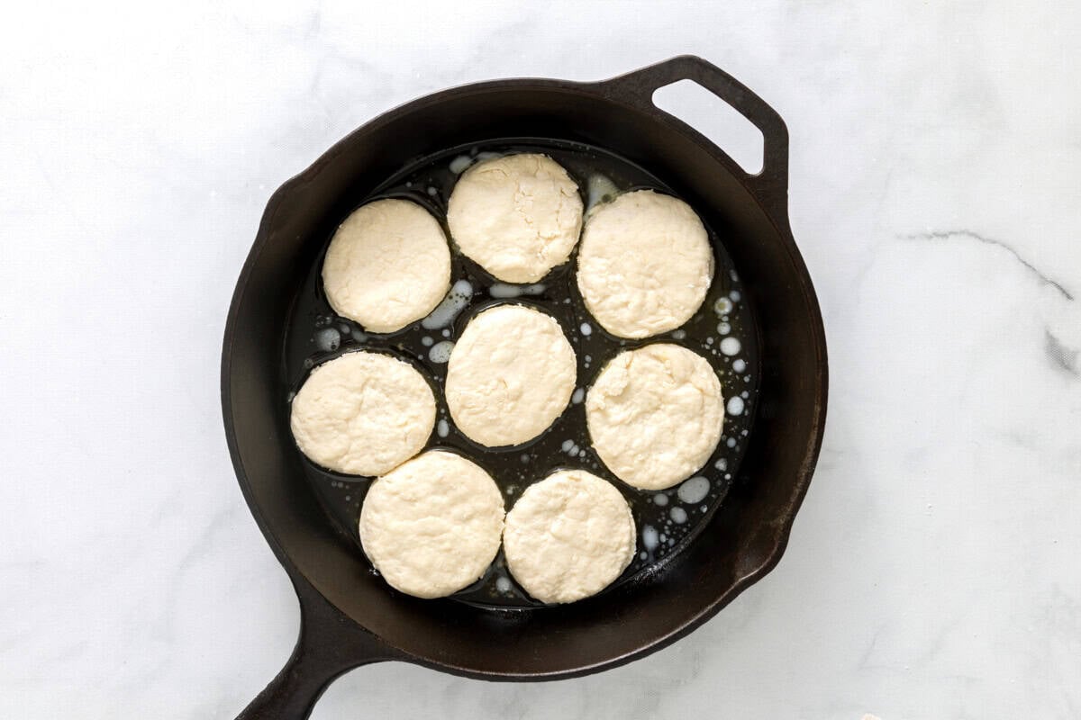 Sprite biscuits in buttered cast iron skillet before baking.