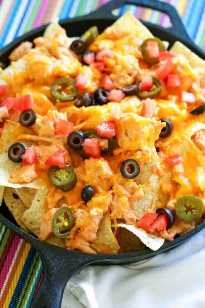 nachos with olives and jalapeños on top 