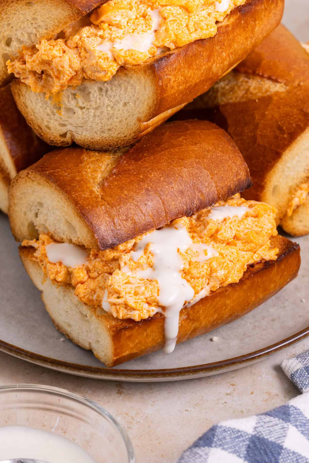 Pile of Buffalo chicken sandwiches with blue cheese dressing.