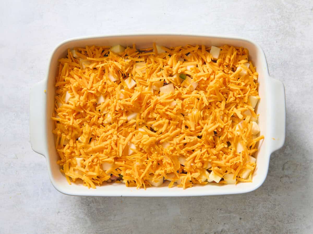 Add-ins layered in casserole dish for overnight breakfast bake.