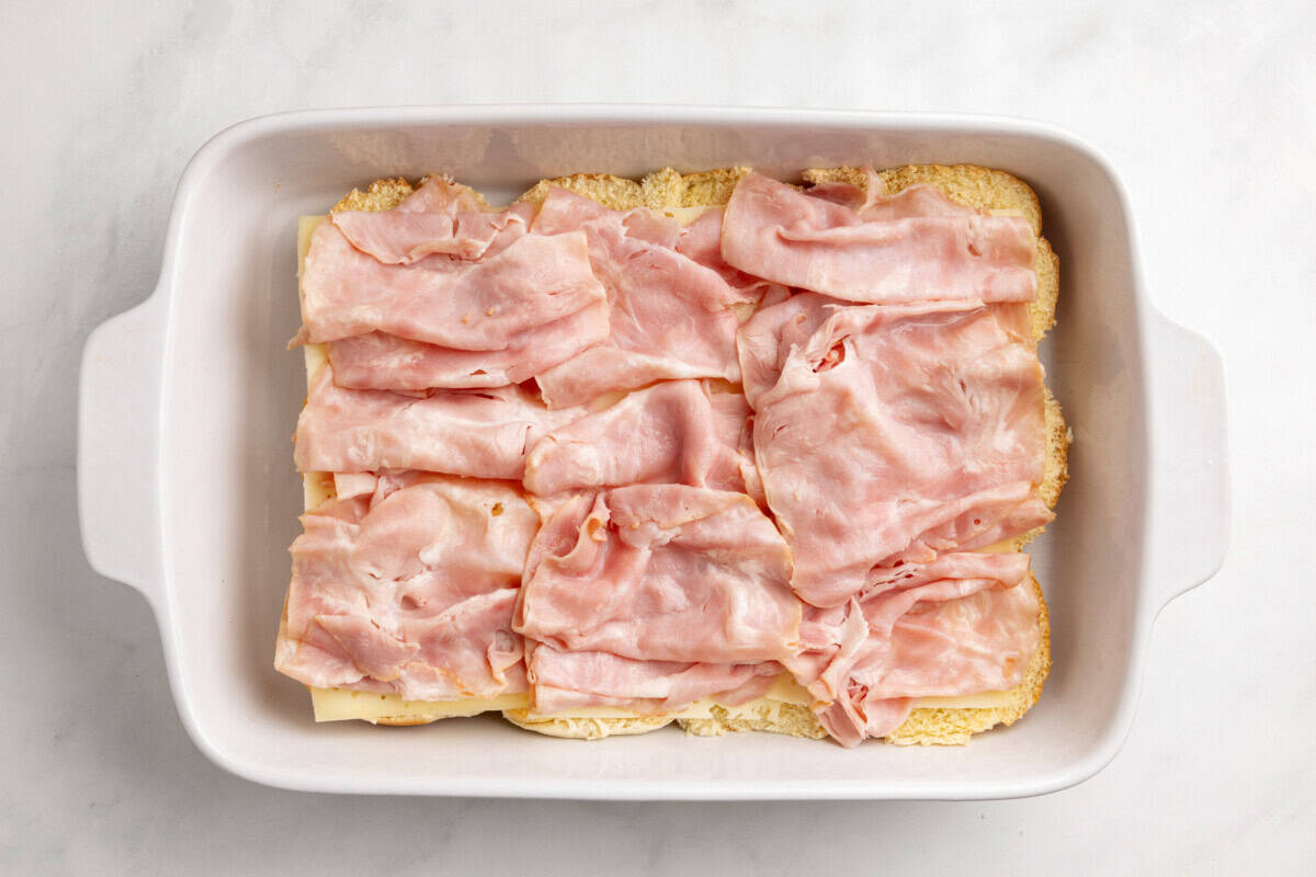 Ham added to baking dish of sliders.