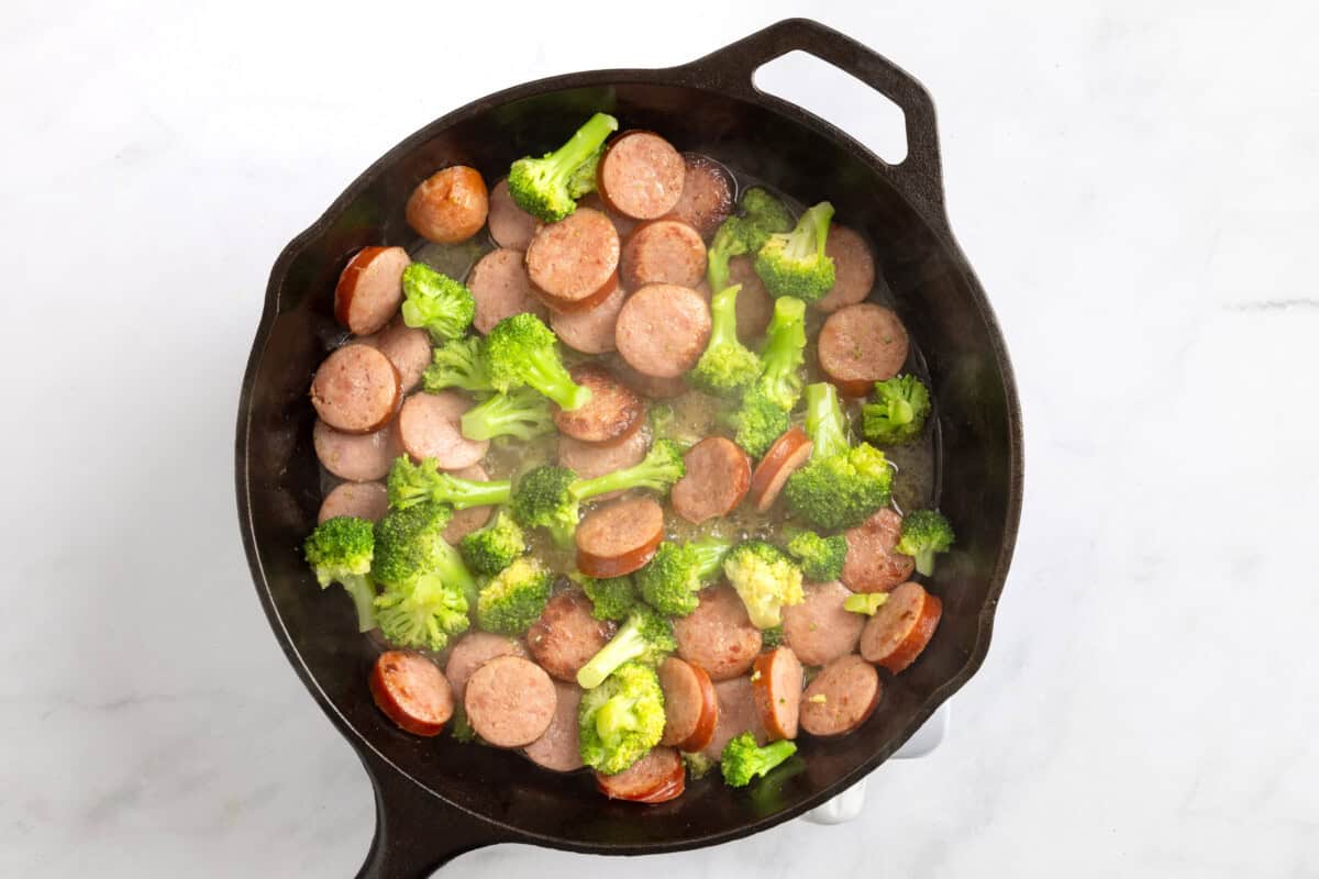 Sausage and broccoli in cast iron skillet.