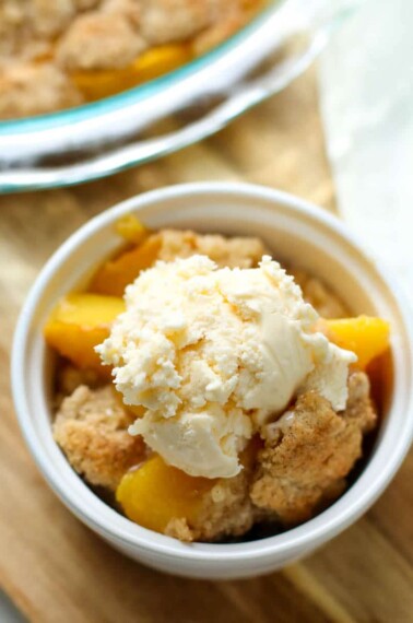 This Easy Peach Cobbler Recipe is by far one of my favorite summer desserts ever!  Made with fresh peaches, butter, and a cookie dough like topping, this will be your go-to cobbler recipe from now on! 