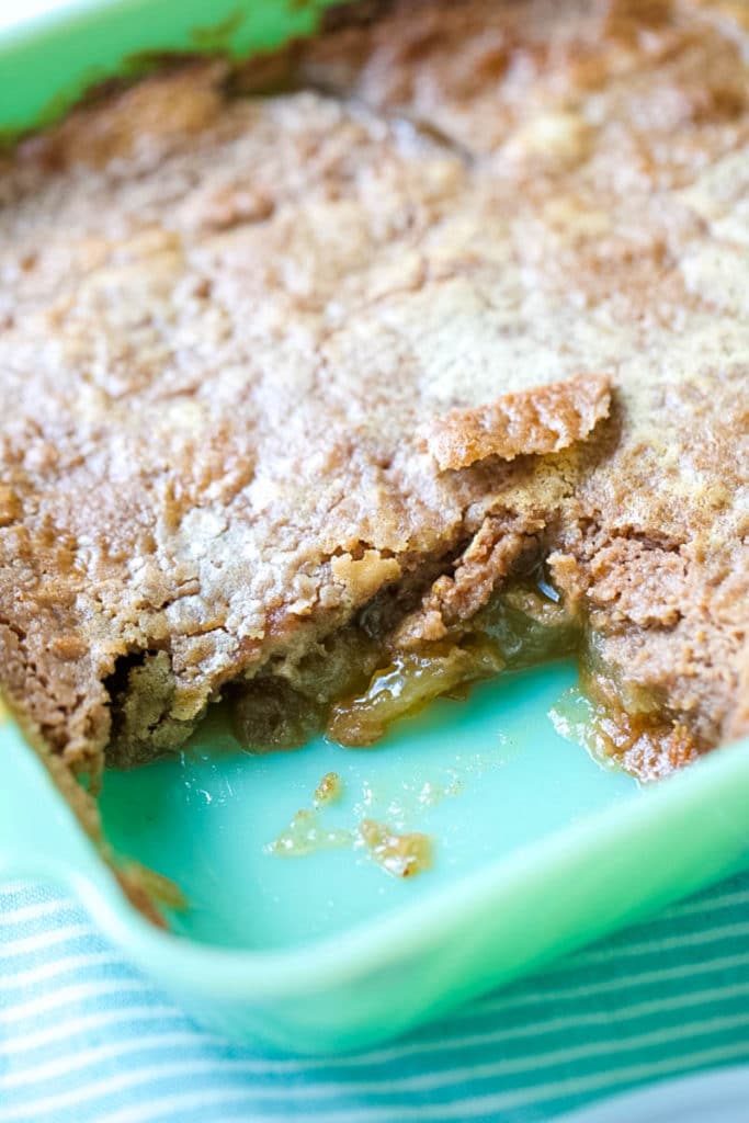 a slice of apple dump cake taken out of the cake pan 