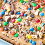 Skip all the hassle of measuring, mixing and scooping cookie dough and create this Chocolate Chip Candy Cookie Bar.  With all the fun flavors of a chocolate chip cookie with loads of candy bar toppings and peanut butter, make these Chocolate Chip Cookie Bars exceptionally special! #chocolatechipcookiebars #chocolatechipcookies #chocolate #cookies #peanutbutter | allthingsmamma.com