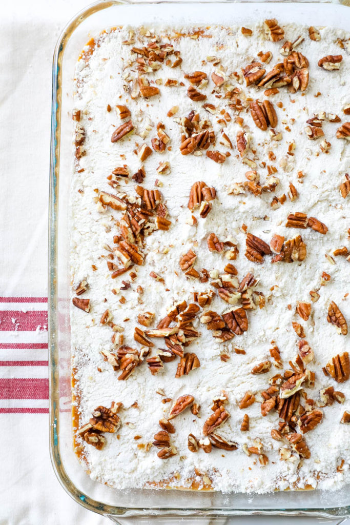 putting the pecans on top of the cake mix 