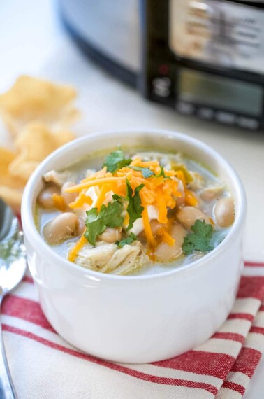 This Easy White Chicken Chili is the perfect slow cooker weeknight meal! Creamy with plenty of toppings, this soup recipe is the perfect way to end the day!