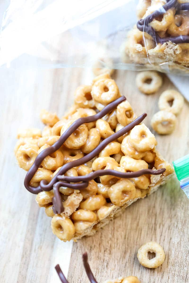 close up of cereal bars with chocolate drizzled on top 