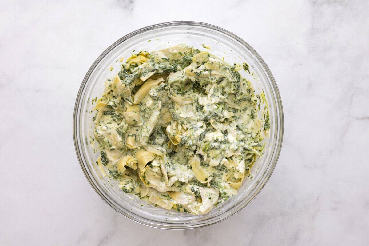 Spinach artichoke dip in glass bowl.