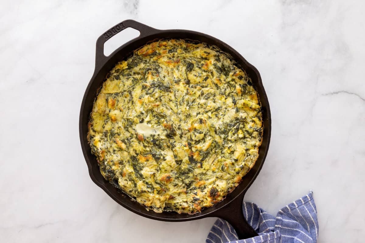 Hot spinach artichoke dip baked in cast iron skillet.