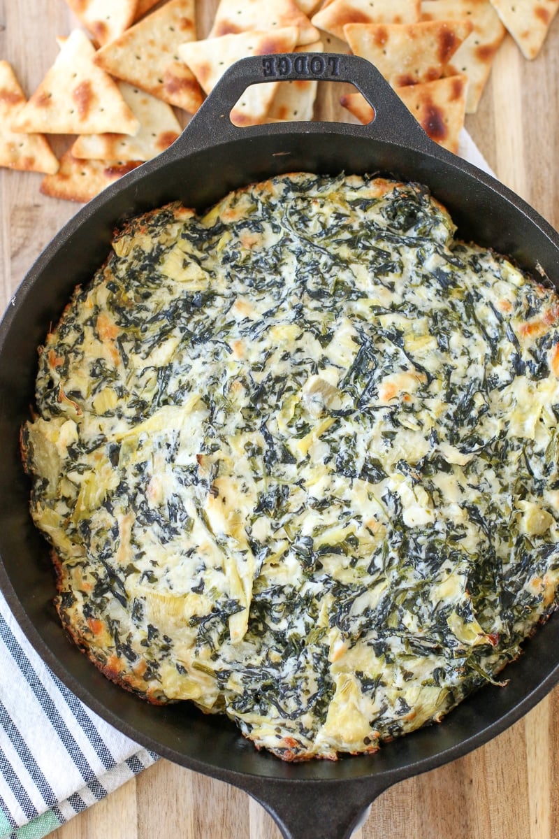 hot spinach artichoke dip in a skillet on a table