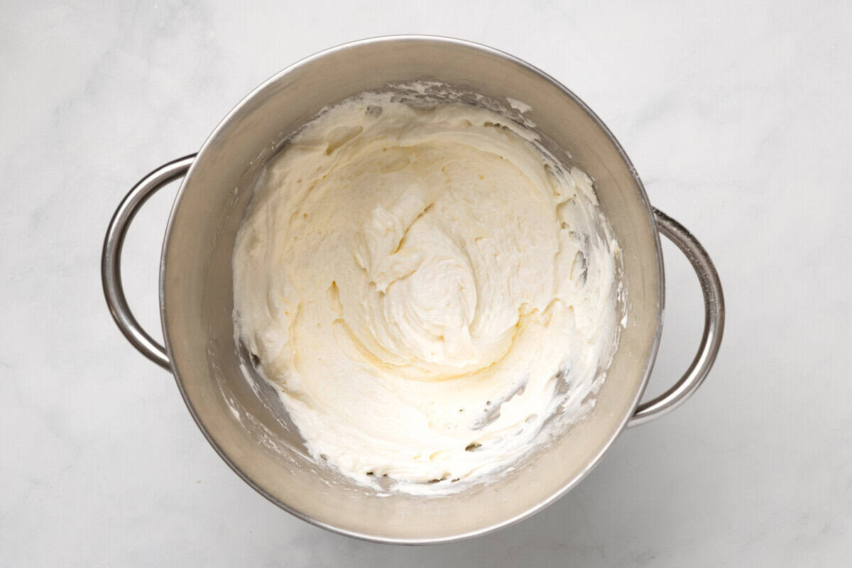 Fluffy buttercream frosting in mixing bowl.