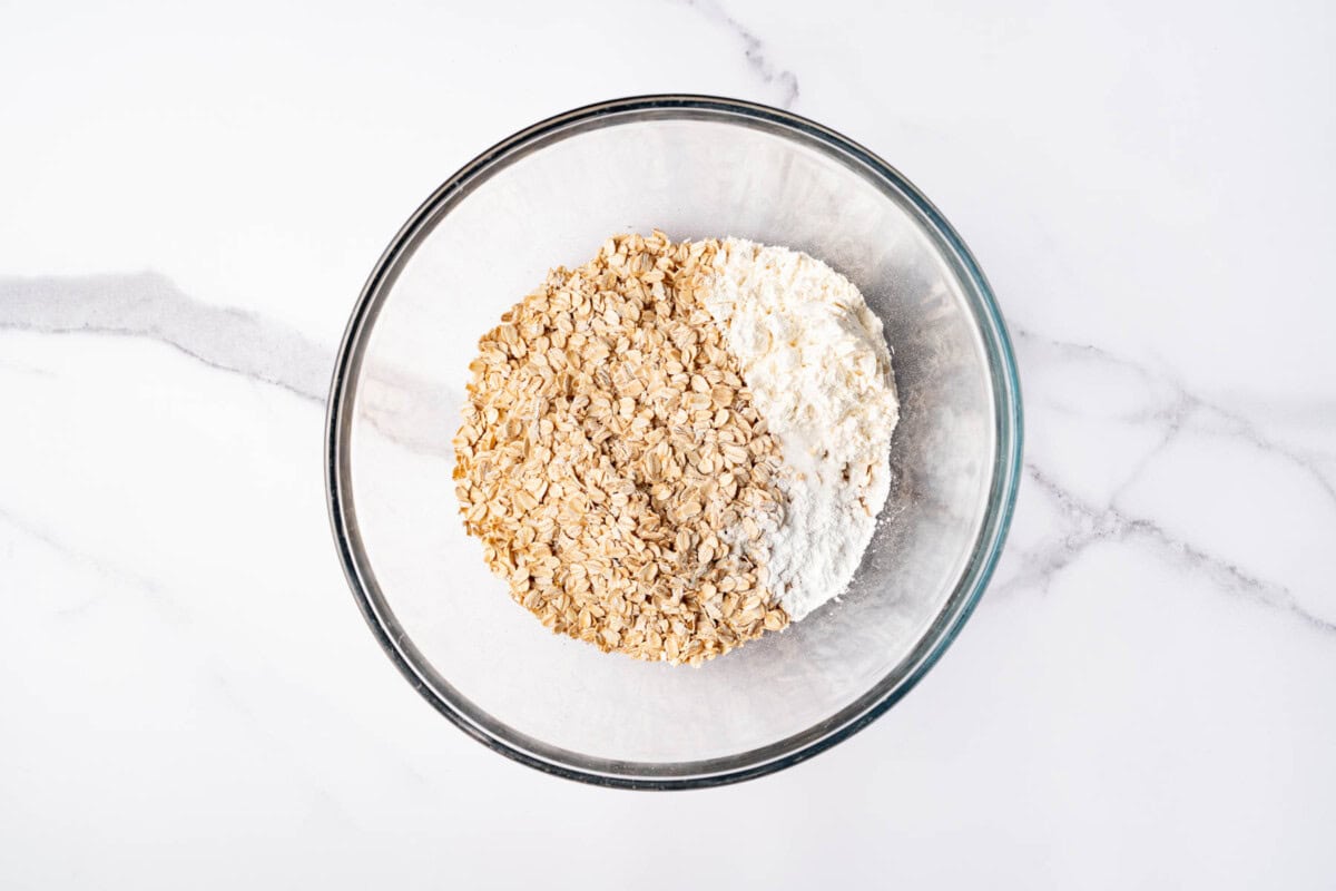 Dry ingredients for oatmeal bars in glass bowl.