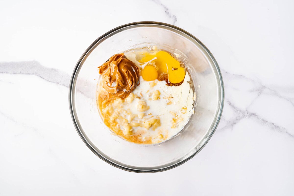 Wet ingredients for oatmeal bars in glass bowl.