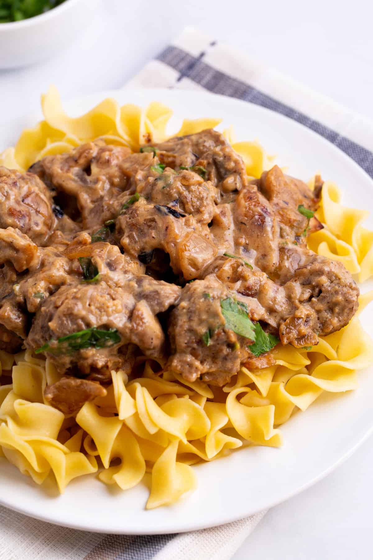 plate of meatball stroganoff laying on a bed of pasta
