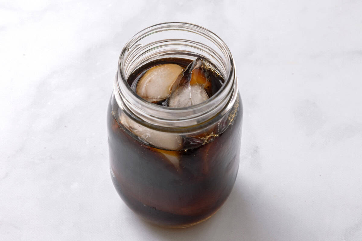 Cold brew poured in jar with ice and syrup.