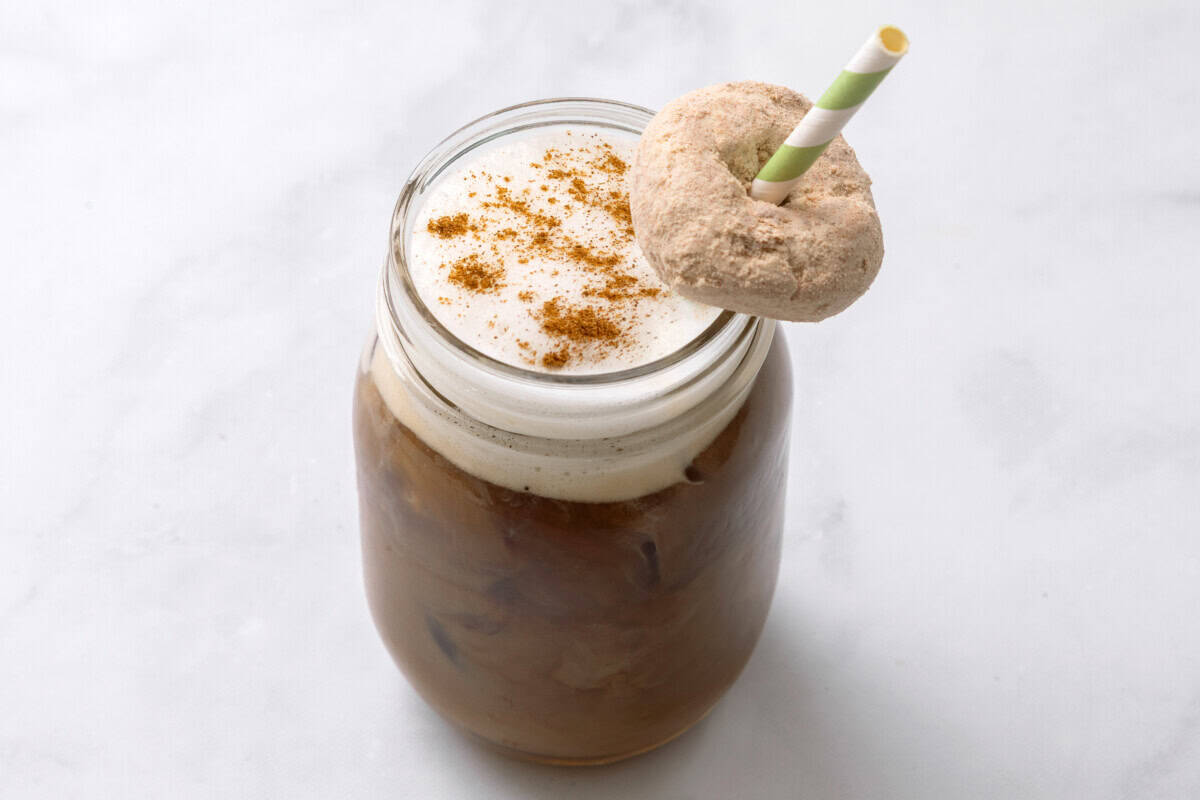 Copycat Starbucks pumpkin spice cold brew coffee with donut hung on straw.