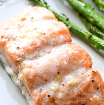 A piece of air fryer salmon next to asparagus.