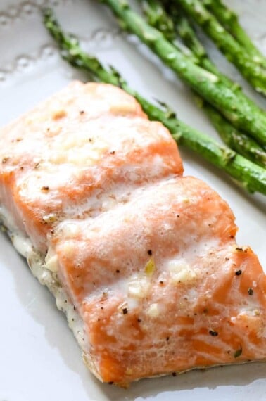 A piece of air fryer salmon next to asparagus.