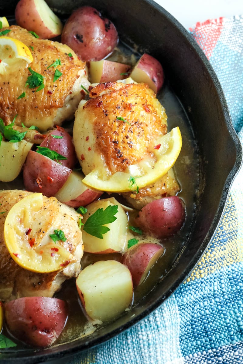 chicken thighs in a skillet with potatoes 