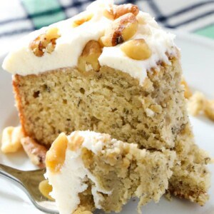 slice of moist banana cake topped with frosting