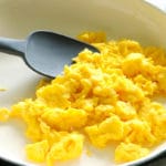 scraping the scrambled eggs with a spatula
