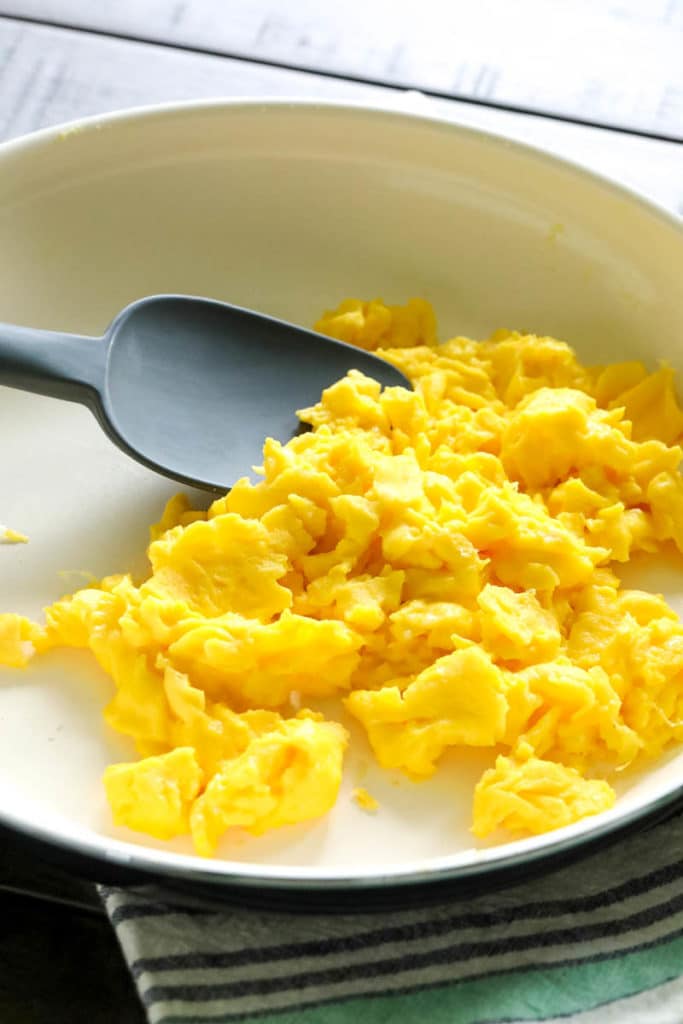 scraping the scrambled eggs with a spatula