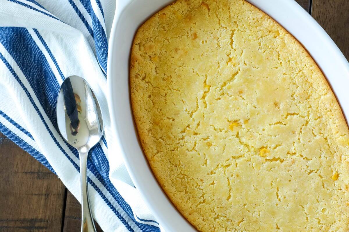 An oval baking dish of corn casserole. 