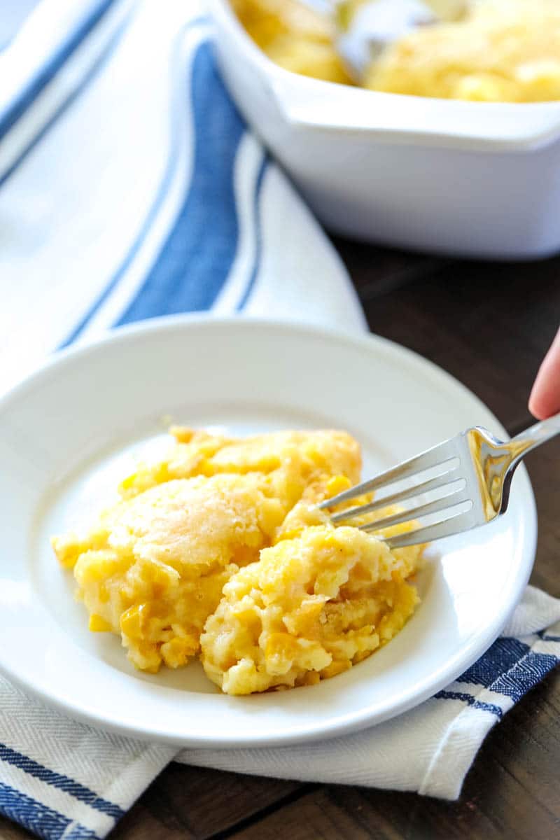 plate of jiffy corn casserole with someone taking a bite 