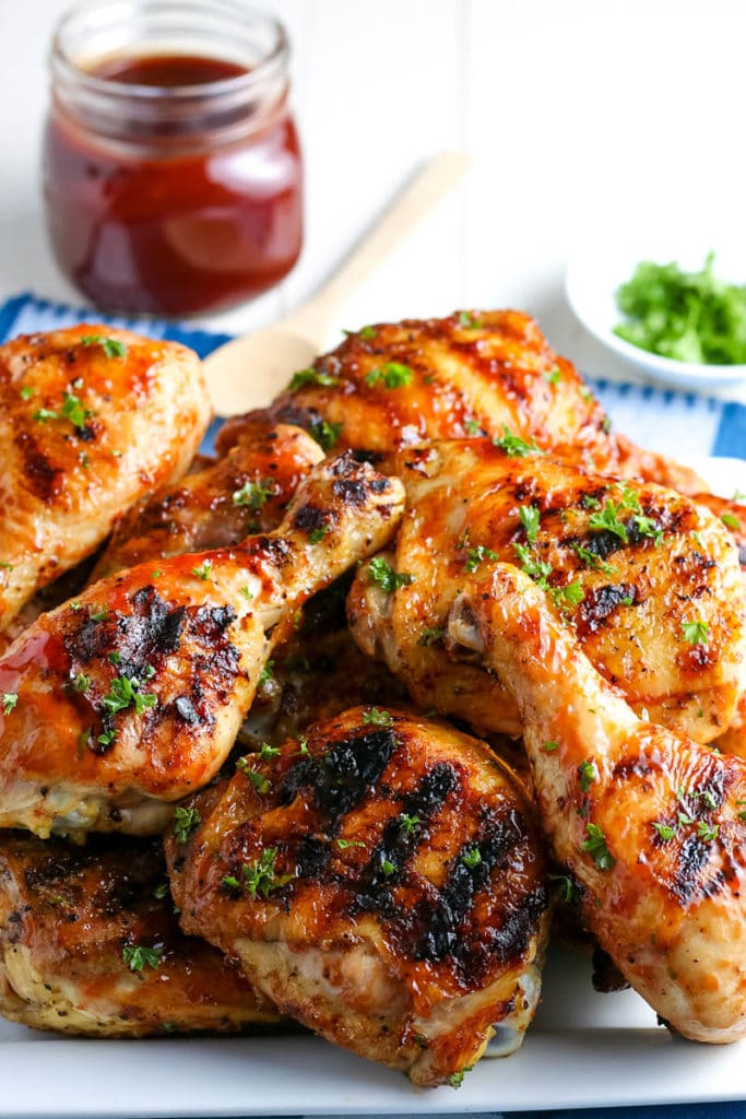 grilled chicken on a platter with BBQ sauce 