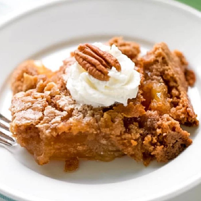 Apple Dump Cake in bowl with whipped cream