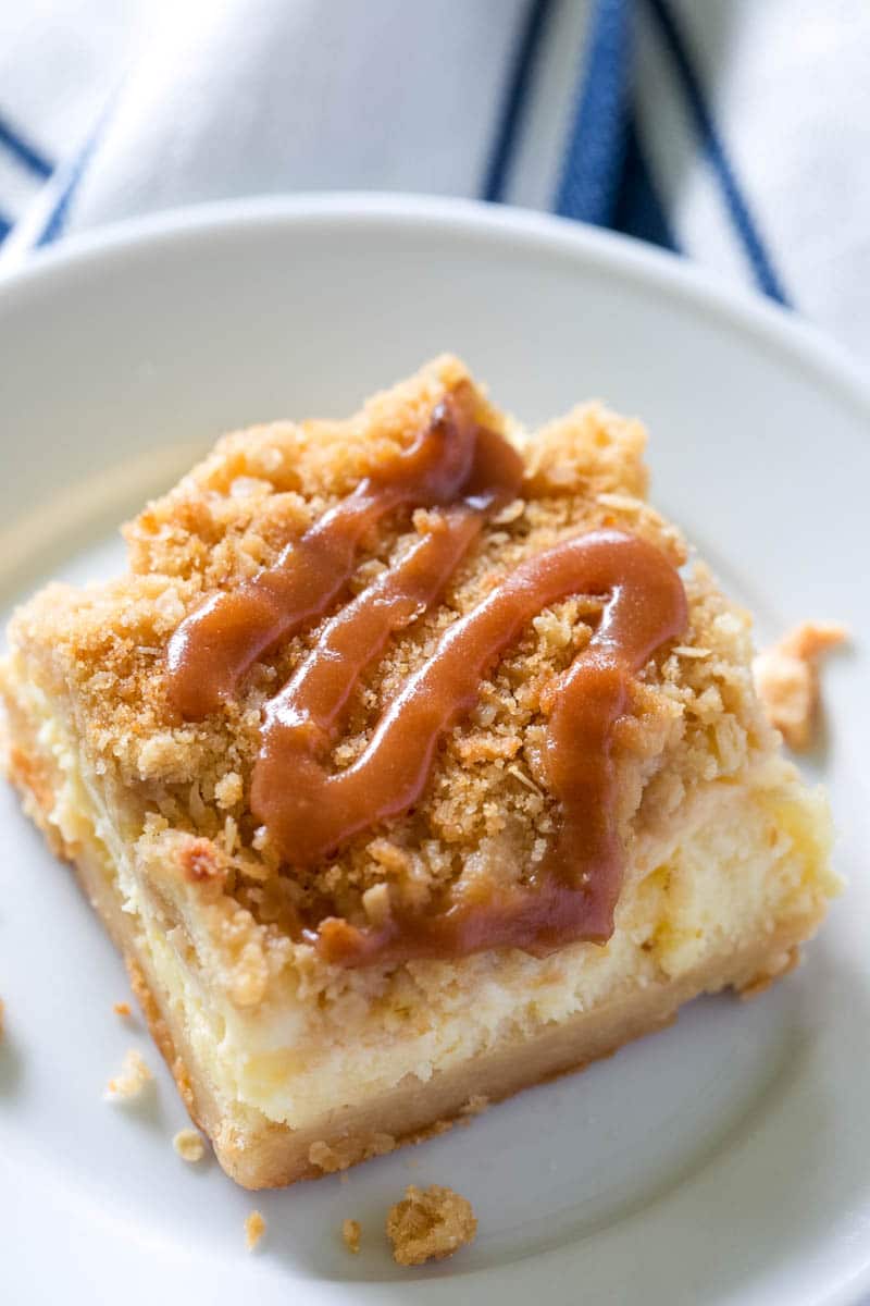 apple cheesecake bar on plate with caramel on top