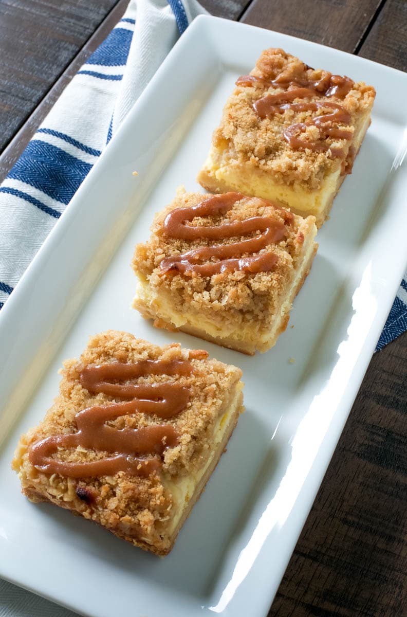 Homemade cheesecake bars on a white platter. 