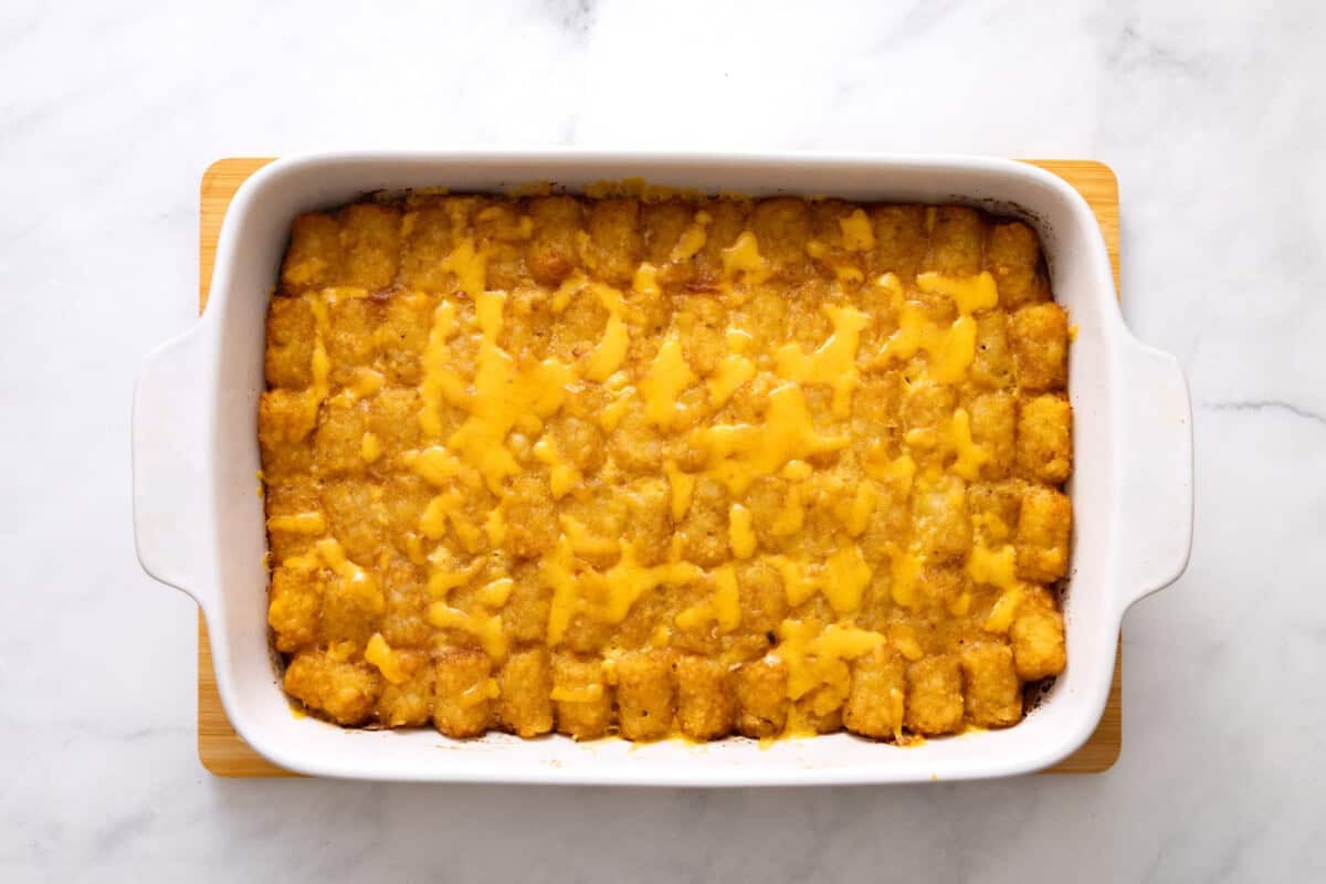 Tater tot breakfast casserole in baking dish with cheese melted on top.