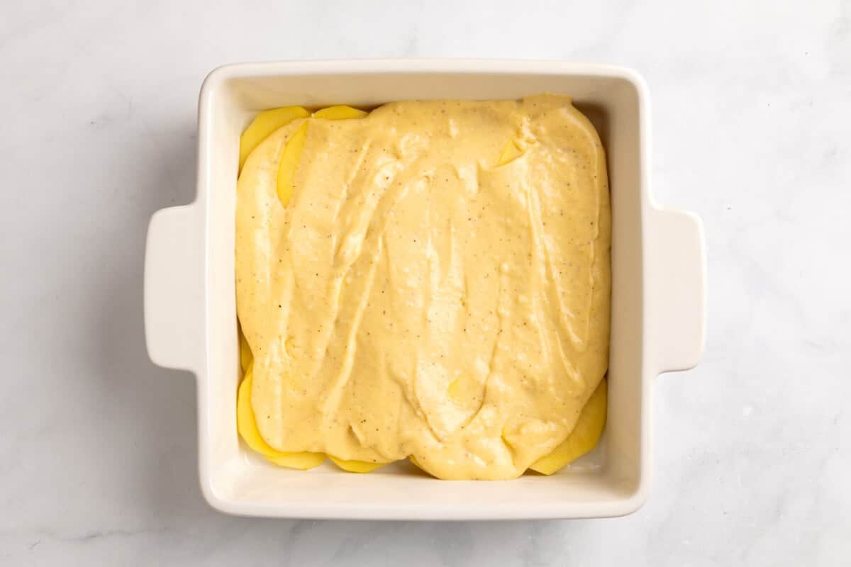 Scalloped potatoes in baking dish before topping.