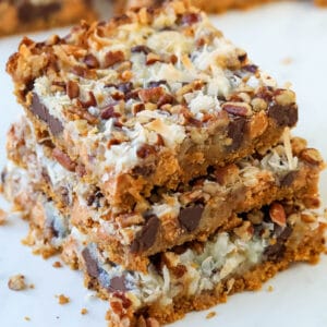 Three 7 layer magic cookie bars on top of each other.