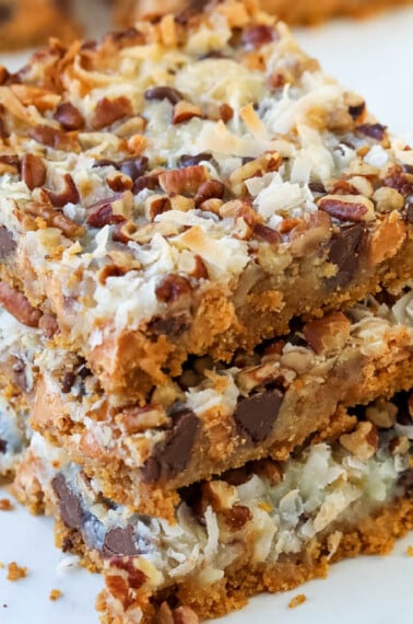 Three 7 layer magic cookie bars on top of each other.