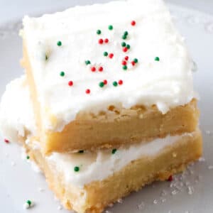 Two sugar cookie bars with red and green sprinkles on top of each other.