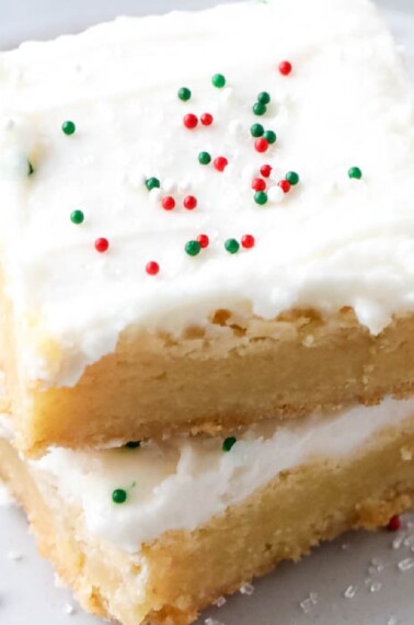 Two sugar cookie bars with red and green sprinkles on top of each other.